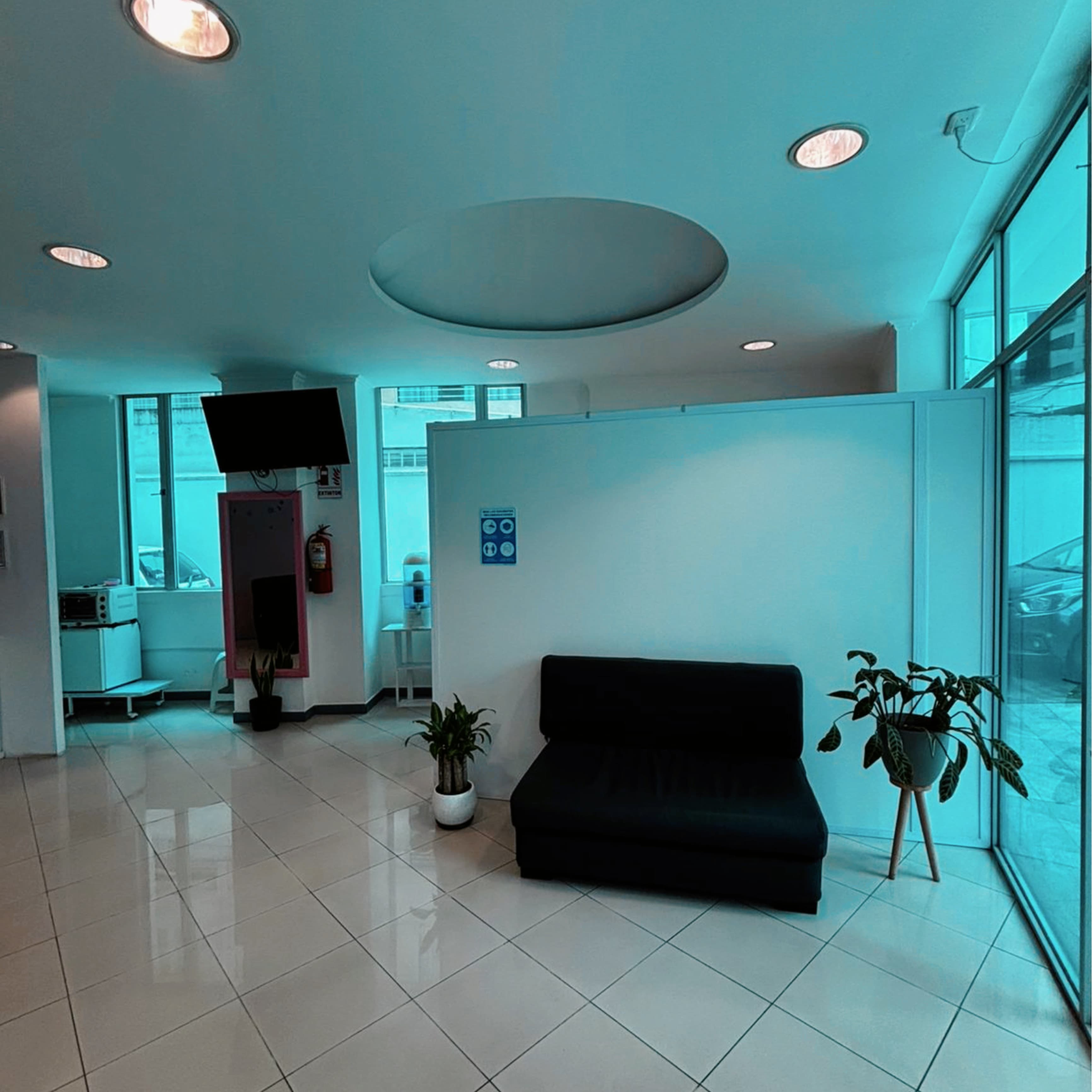 Sala de espera iluminada con ventanales grandes y decoracion moderna